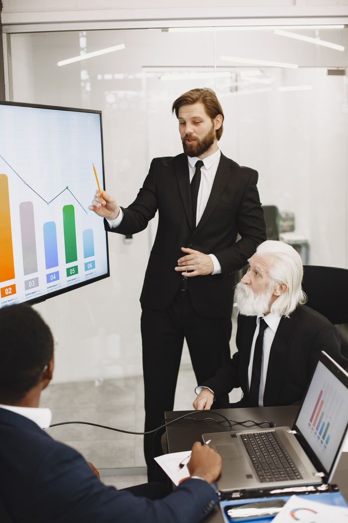 Business professionals discussing analytics in a corporate meeting room.